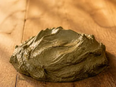 Texture d'argile verte humide sur une table en bois