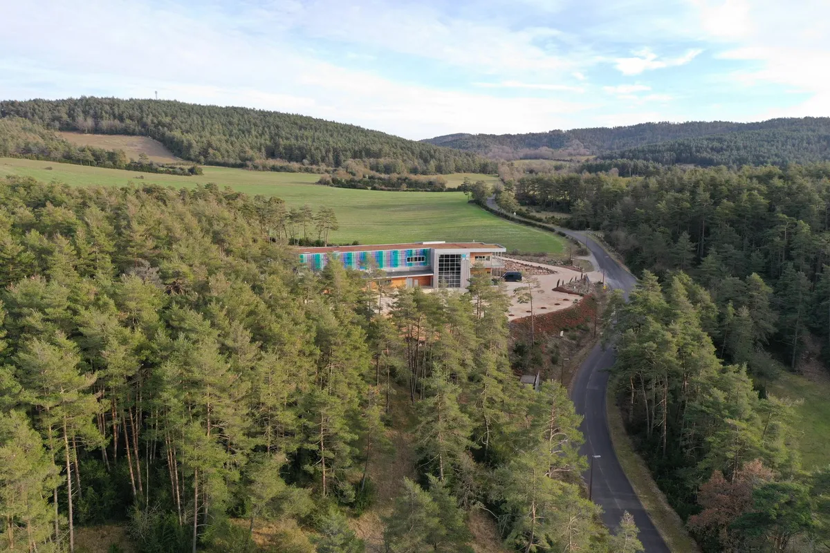 Vue aérienne de la distillerie Essenciagua au milieu de la forêt lozérienne