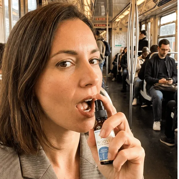 Une femme pulvérise un spray YNOOVI sous sa langue dans une rame de métro